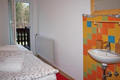 a bathroom with a sink and a bed in a room at Apartments and rooms Cerkovnik in Bohinj