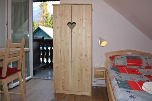 a bedroom with a wooden cabinet next to a bed at Apartments and rooms Cerkovnik in Bohinj