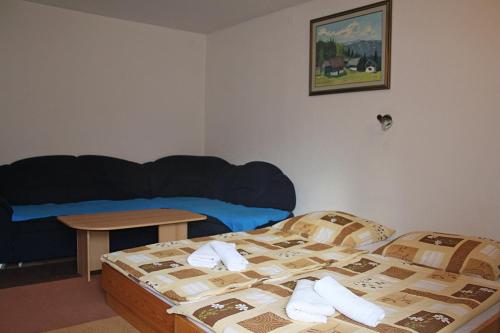 a bedroom with a bed and a table and a couch at Apartments and rooms Cerkovnik in Bohinj