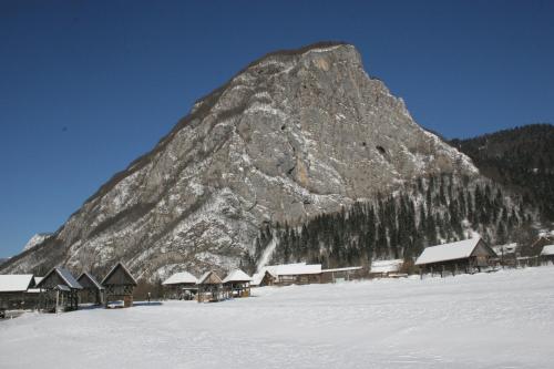 a mountain with a bunch of houses in the snow at Apartments and rooms Cerkovnik in Bohinj