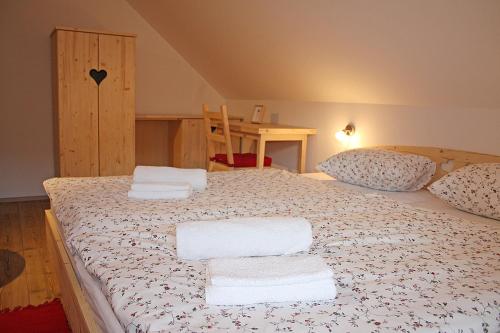 a bedroom with a large bed with towels on it at Apartments and rooms Cerkovnik in Bohinj