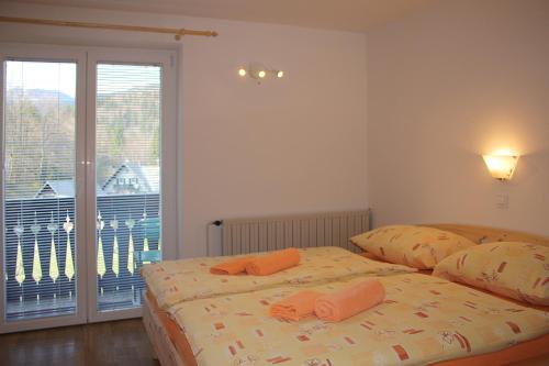 a bedroom with a bed with orange towels on it at Apartments and rooms Cerkovnik in Bohinj