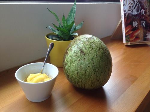 a melon sitting on a table with a bowl of butter at A-nana Cottage in Puli