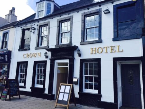 a white hotel with a sign in front of it at The Crown Hotel in Peebles