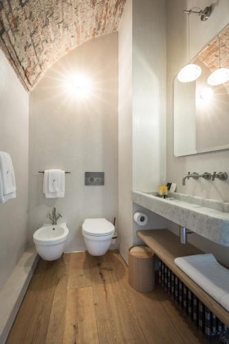 a bathroom with a white toilet and a sink at Locanda La Raia in Gavi