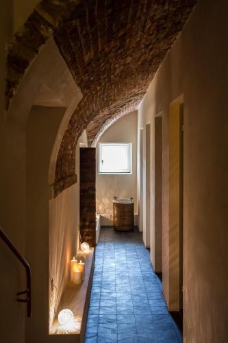 a hallway of a house with an archway and candles at Locanda La Raia in Gavi