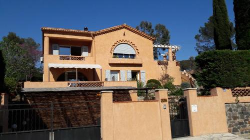 une grande maison avec une clôture devant dans l'établissement L'Ecureuil de l'Estérel, à Saint-Raphaël