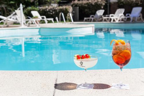 a drink and a bowl of fruit next to a swimming pool at Claridge Hotel in Buenos Aires