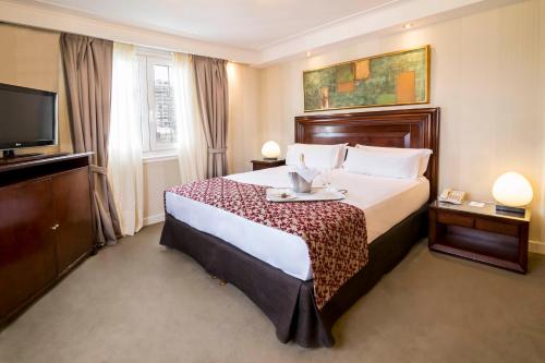 A bed or beds in a room at Claridge Hotel