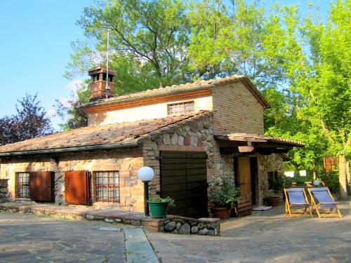 una casa in pietra con un camino sopra di Belvilla by OYO Casa Le Meridiane a Chiusdino