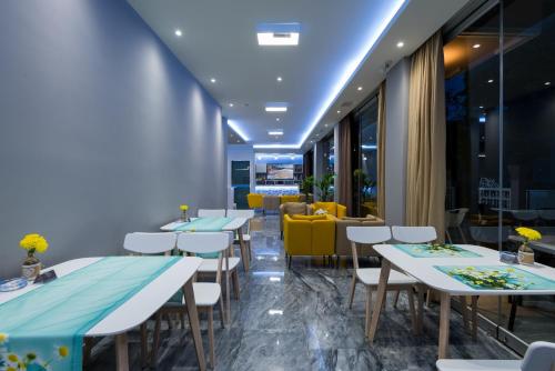 a row of tables in a restaurant with yellow chairs at Olympia Hotel in Kos Town