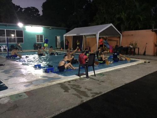 a group of people in a swimming pool at night at Cabañas Colindas in Panama City