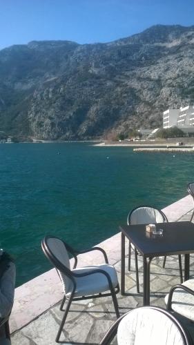 a table and chairs next to a body of water at Apartments Montenegro Risan Čučković in Risan