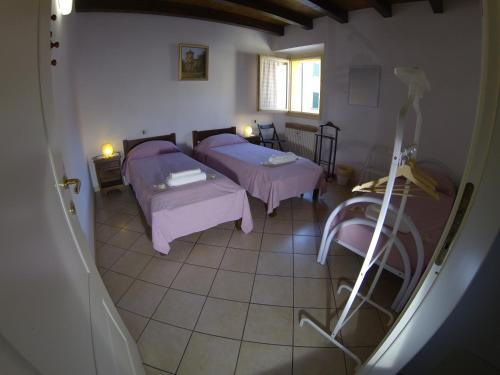a room with two beds and a window at R&B Ostello Degli Dei in Monzuno