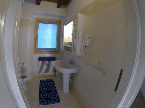 a bathroom with a sink and a toilet and a window at R&B Ostello Degli Dei in Monzuno