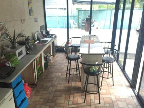 a kitchen with a counter and stools in a room at Cabañas Colindas in Panama City