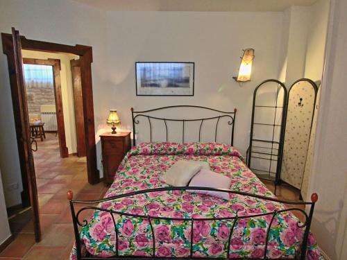 Un dormitorio con una cama con una colcha floral. en Family Cottage in Cagli with Pool, en Acqualagna