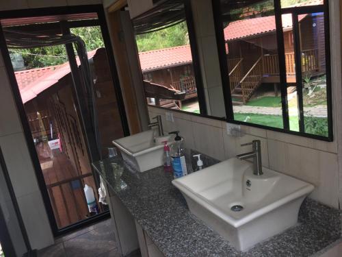 Baño con 2 lavabos y espejo en Cabañas Colindas, en Panamá