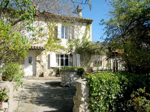 ein altes Steinhaus mit einem Tor davor in der Unterkunft Charming holiday home with private pool in Cavaillon