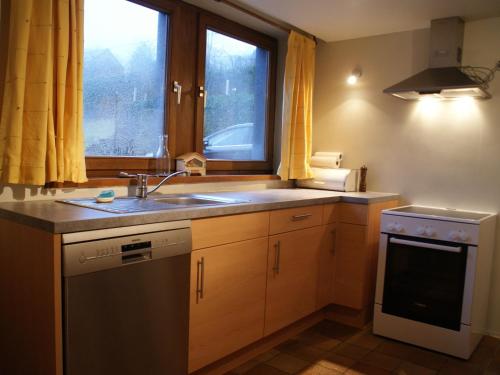 een keuken met een wastafel en een raam bij Quaint Cottage in Egb mont with Garden in Exbomont