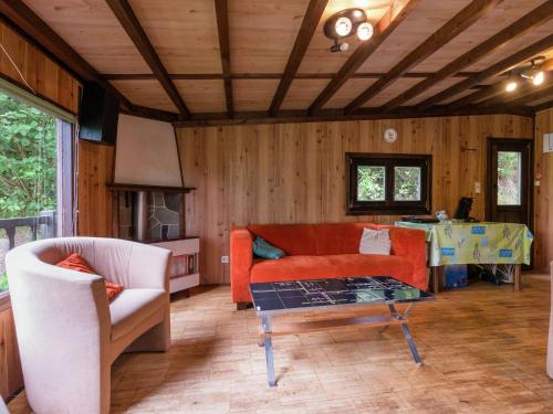 ein Wohnzimmer mit einem Sofa und einem Tisch in der Unterkunft Sympathic Chalet not far from La Roche en Ardennes in La-Roche-en-Ardenne