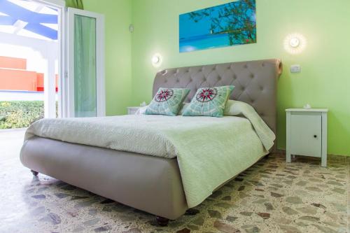 um quarto com uma cama grande e uma cabeceira. em Blu d'aMare B&B em Porto Cesareo