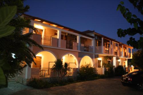 a large white building with balconies at night at Antonio Studios in Alikanas