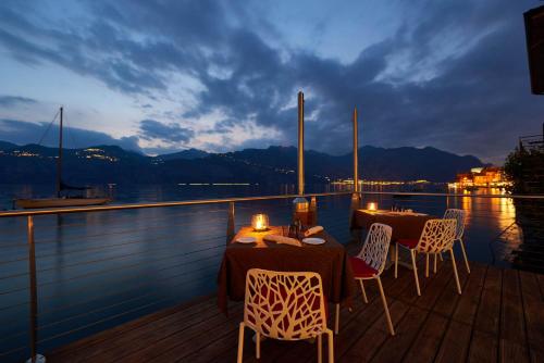 two tables and chairs on the deck of a boat at Hotel Venezia in Malcesine