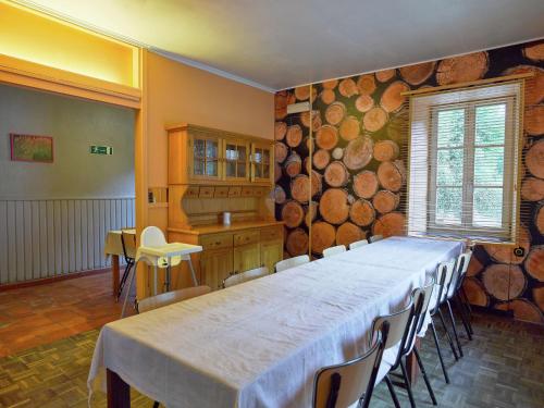 a dining room with a table and a large wall of logs at Spacious Family Home, Sosoye in Sosoye