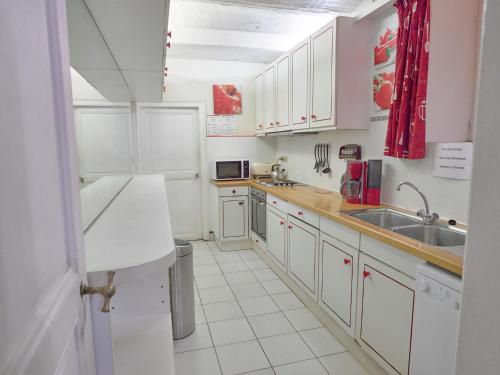 a white kitchen with white cabinets and a sink at Spacious Family Home, Sosoye in Sosoye