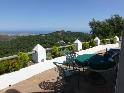a table and chairs on a balcony with a view at Belvilla by OYO Las Cerezas in Casares