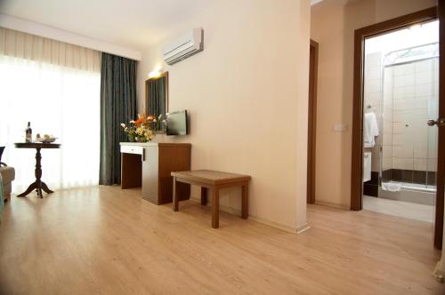 a living room with a table and a television at Supreme Hotel in Marmaris