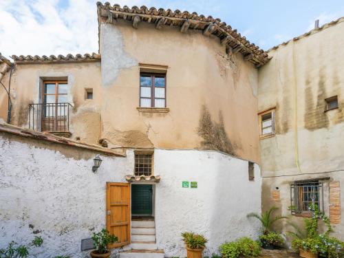 Una casa vieja con una puerta en el costado. en Belvilla by OYO El Rac, en Pacs del Penedès