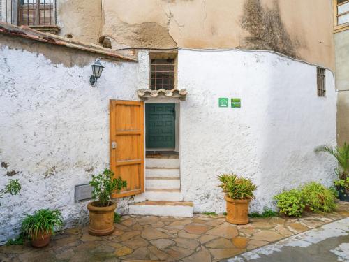 un edificio blanco con puerta de madera y macetas en Belvilla by OYO El Rac, en Pacs del Penedès