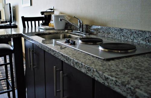 a kitchen with a sink and a counter top with a counter top at Sigma Inn & Suites in Melville