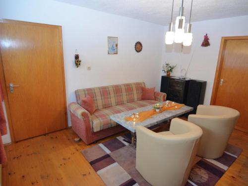 a living room with a couch and a table and chairs at Holiday home near the ski slope in Stadlern