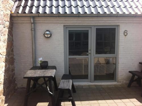 a patio with a table and benches in front of a building at Tollundgaard Golf Park & Apartments in Funder Kirkeby