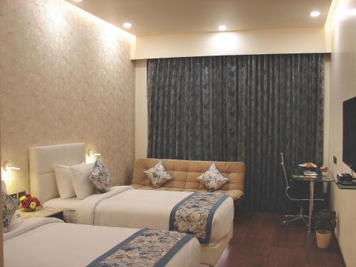 a hotel room with two beds and a window at Hotel Grand Maple in Jaipur