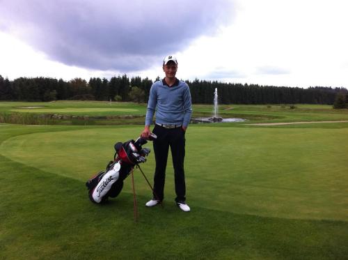 a woman standing next to a golf cart on a course at Tollundgaard Golf Park & Apartments in Funder Kirkeby