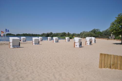 a beach with many white chairs in the sand at Tawerna Panorama in Stepnica