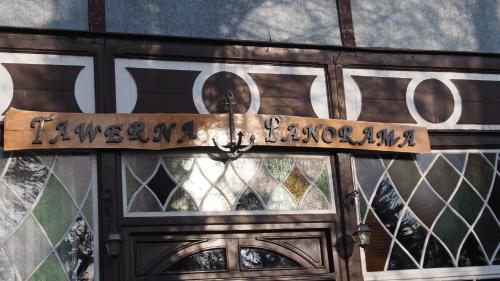 a sign on the door of a building with stained glass at Tawerna Panorama in Stepnica