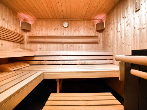 uma sauna de madeira com um banco no meio em Luxurious Mansion with indoor pool and Sauna em Mesnil-Saint-Blaise
