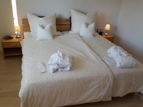 ein Schlafzimmer mit einem großen weißen Bett mit Handtüchern darauf in der Unterkunft Ferienwohnung Hoherting in Prien am Chiemsee