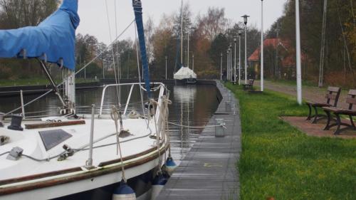 a boat is docked in a canal with benches at Tawerna Panorama in Stepnica