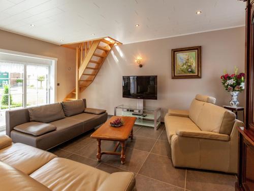 een woonkamer met 2 banken en een tv bij Delightful cottage surrounded by nature in Warneton