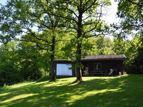 a small cabin in the middle of a yard with trees at Modern Chalet with Private Tennis Court in Humain in Humain