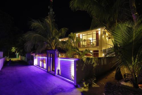 a house with purple lights in front of it at Shallow Lagoon Rasdhoo in Rasdu