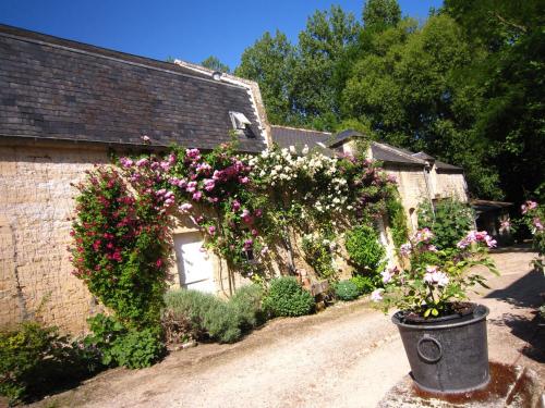a garden with flowers on the side of a building at Cozy Holiday Home in Lantheuil with Garden in Lantheuil