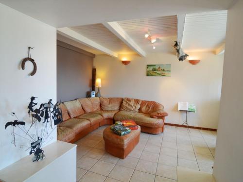 a living room with a brown leather couch at Modern Farmhouse in Chassepierre with Terrace in Chassepierre