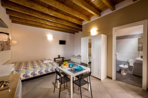 a bedroom with a bed and a table and chairs at Il Cortile in Castellammare del Golfo